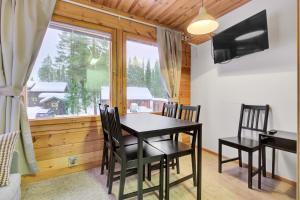 a dining room with a table and chairs and a window at Pyhäkoti D - 30 Meters From the Slopes in Pyhätunturi +16 photos