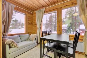 a living room with a table and a couch at Pyhäkoti D - 30 Meters From the Slopes - Valkea Homes in Pyhätunturi