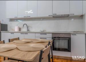 a kitchen with a wooden table and an oven at VASKO Luxury Suites 4 in Siátista