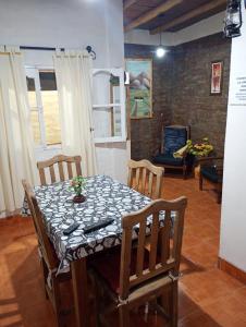 een eettafel met stoelen en een tafel en een stoel bij Casa Cómoda en Barreal in Barreal