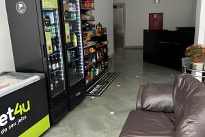 een winkel met een bank naast een automaat bij No centro com Varanda, Smart Tv, Elevador e Garagem Paga in Viçosa
