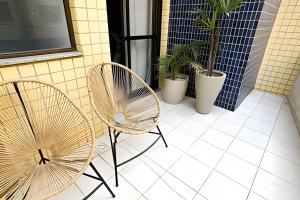 twee stoelen en een tafel op een patio bij No centro com Varanda, Smart Tv, Elevador e Garagem Paga in Viçosa