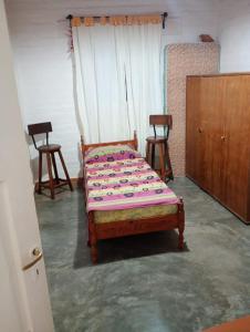 un letto in una stanza con due sedie di Casa Cómoda en Barreal a Barreal