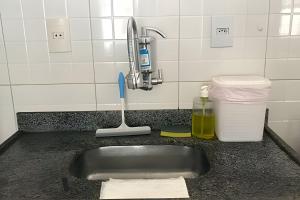 ein Waschbecken mit Zahnbürste und Wasserhahn in der Unterkunft Kitnet na rua da UFV com Smart TV e Garagem in Viçosa