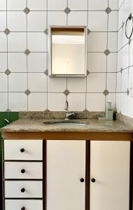 een badkamer met een wastafel en een spiegel bij No centro com Varanda, Smart Tv, Elevador e Garagem Paga in Viçosa