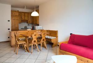 a kitchen with a wooden table and a red couch at Cassina Lavallee 8 in Cremeno +10 photos