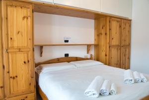 a bedroom with a large white bed with wooden cabinets at Cassina Lavallee 8 in Cremeno