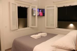 a bedroom with a bed with two towels on it at FaliroRelax F2 in Athens