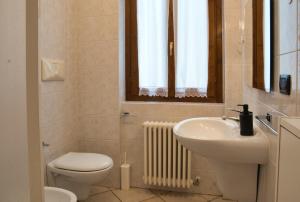 a bathroom with a sink and a toilet and a window at Cassina Lavallee 8 in Cremeno
