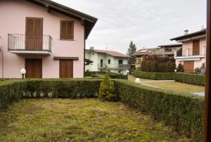a pink house with a hedge in front of it at Cassina Lavallee 8 in Cremeno
