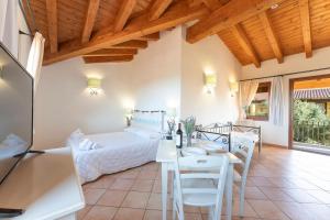 een kamer met een bed, een tafel en stoelen bij Functional studio with shared pool in Vignola Mare