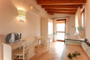 een woonkamer met een tafel en een tv op een bureau bij Functional studio with shared pool in Vignola Mare