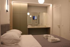 a bedroom with a bed and a bathroom with a mirror at FaliroRelax F2 in Athens +34 photos