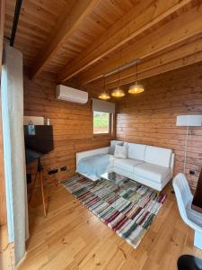 ein Wohnzimmer mit einem weißen Sofa und einem Fernseher in der Unterkunft Sunset Eco Shelter 1 in Ponta do Pargo