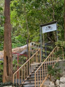 a staircase with a sign next to a tree at Rockviewstay in Kalpetta