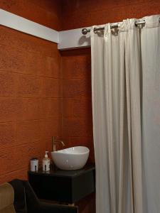a bathroom with a white shower curtain and a sink at Rockviewstay in Kalpetta