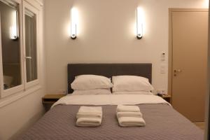 a bedroom with a bed with two towels on it at FaliroRelax F2 in Athens