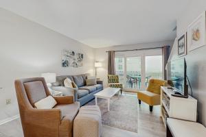 een woonkamer met een bank en een tv bij Fort Morgan Townhomes E7 in Fort Morgan