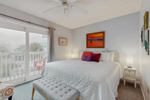 een witte slaapkamer met een bed en een balkon bij Fort Morgan Townhomes E7 in Fort Morgan +20 foto's