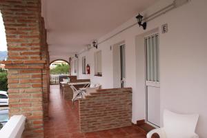a room with white chairs and a brick wall at Apartamentos Bolonia Paraiso in Bolonia