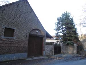 um edifício de tijolos com uma grande porta em B&B Bodegem em Dilbeek