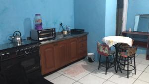 eine Küche mit einer Spüle, einem Herd und einer Arbeitsplatte in der Unterkunft Kit Net in Torres