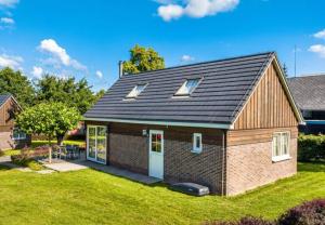 een klein bakstenen huis met ramen op een tuin bij Camping 2000 - Vakantiewoning XL in Osečná