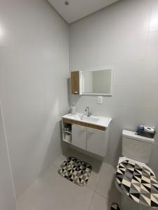 een witte badkamer met een wastafel en een toilet bij Apartamento Elegante 2 Quartos in Balneário Camboriú +27 foto's