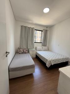 een slaapkamer met twee bedden en een raam bij Apartamento Elegante 2 Quartos in Balneário Camboriú