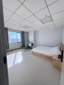 ein Schlafzimmer mit einem Bett und einem Schreibtisch in der Unterkunft Tangmu Hostel in Kunming