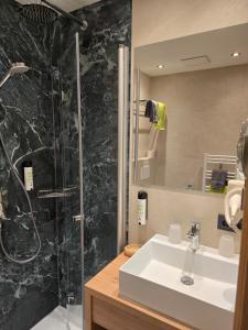 un baño con lavabo y ducha en Wellness Pension Hollaus, en Kirchberg in Tirol 58 fotos más