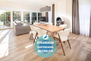 于斯德Winkelschiffchen II mit Sauna的配有木桌和白色椅子的餐厅