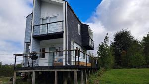a large house with a balcony on top of it at Casa Campo Chiloé in Chonchi