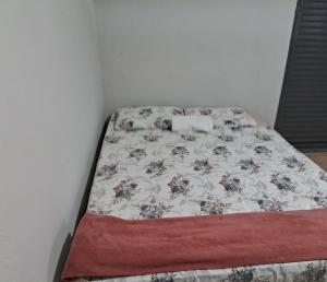 een klein bed in een hoek van een kamer bij Pousada Central in Montes Claros