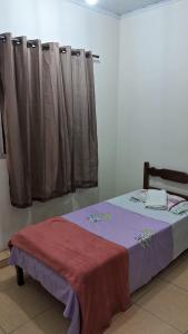 een slaapkamer met een bed met een rode deken bij Pousada Central in Montes Claros