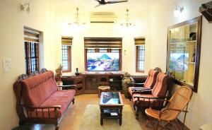 a living room with two couches and a flat screen tv at White Haven in Angamaly