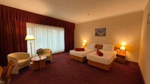 乌尔根奇Khorezm Palace Hotel的酒店客房设有一间带两张床的卧室