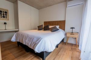 ein Schlafzimmer mit einem Bett mit weißen Laken und Kissen in der Unterkunft Live Smart in Montevideo