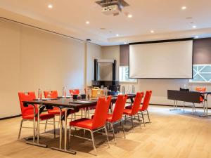 a conference room with a table and chairs and a projection screen at ibis Dubai One Central in Dubai