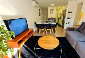 a living room with a couch and a dining room at Apartamento Loft Gramado in Gramado