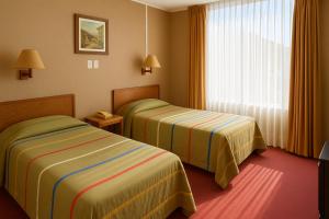 una camera d'albergo con due letti e una finestra di Hotel de Viña a Viña del Mar