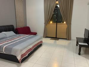 a bedroom with a bed and a chair and a desk at Woon homestay 2 in Balik Pulau