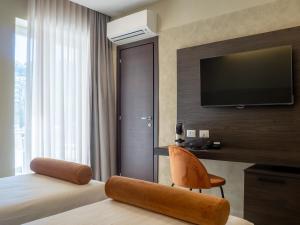 N42 Hotel في نابولي: غرفة فندق بها سرير وجهاز تلفزيون معلق على الحائط