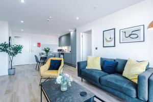 een woonkamer met een blauwe bank en een tafel bij City View Apartment with Pool in Manchester