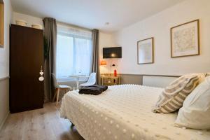 een slaapkamer met een bed, een tafel en een raam bij Studio Vauban, Lille in Lille
