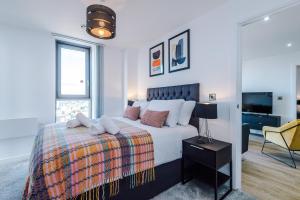 een witte slaapkamer met een bed en een spiegel bij City View Apartment with Pool in Manchester