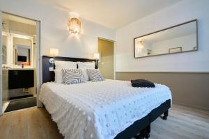 een slaapkamer met een groot wit bed met een grote spiegel bij Studio Vauban, Lille in Lille