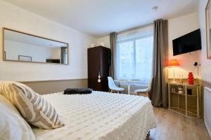 een slaapkamer met een bed, een tafel en een spiegel bij Studio Vauban, Lille in Lille +21 foto's