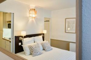 een slaapkamer met een bed met witte kussens bij Studio Vauban, Lille in Lille