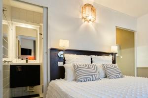 een slaapkamer met een bed met een spiegel en een kroonluchter bij Studio Vauban, Lille in Lille